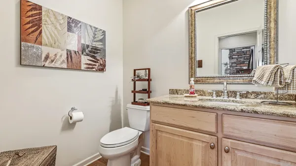 a bathroom with a granite countertop toilet sink and mirror