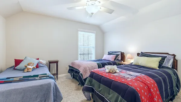 a bedroom with two beds and a chandelier