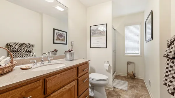 a bathroom with a granite countertop sink mirror vanity and toilet