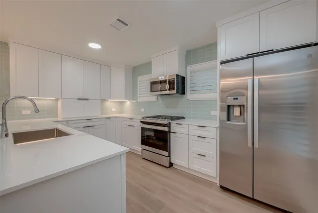 a kitchen with a refrigerator sink and stove