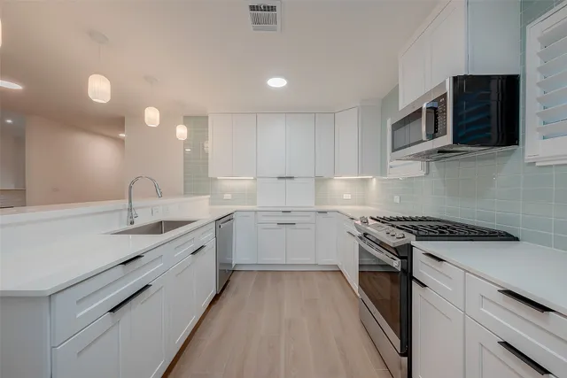 a kitchen with stainless steel appliances granite countertop a sink and a stove