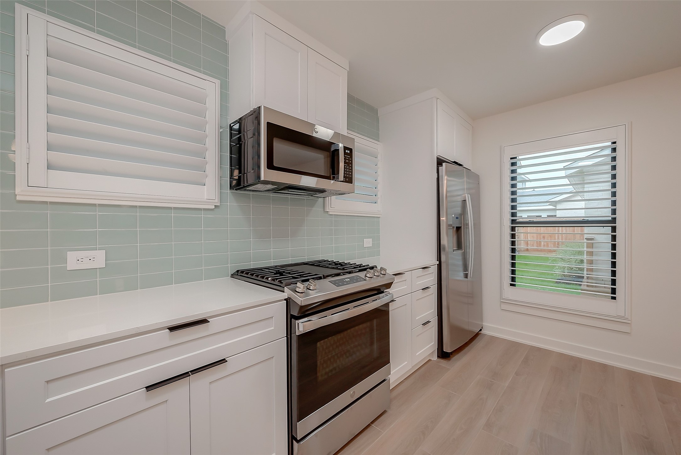 2702 Delano Street Houston, TX 77004 - Photo 23 of 45 a kitchen with white cabinets stainless steel appliances and wooden floor