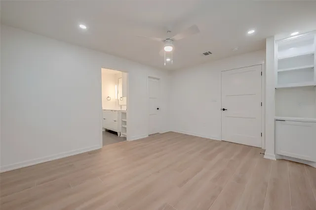 an empty room with wooden floor and window