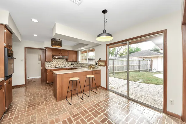 a kitchen with stainless steel appliances granite countertop a stove a sink and a refrigerator