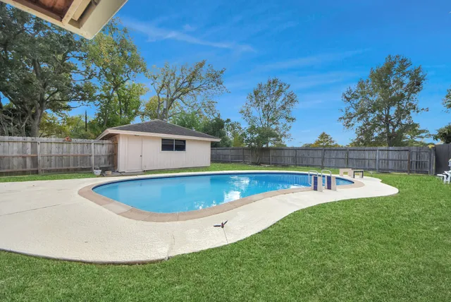 a view of a backyard with swimming pool and deck