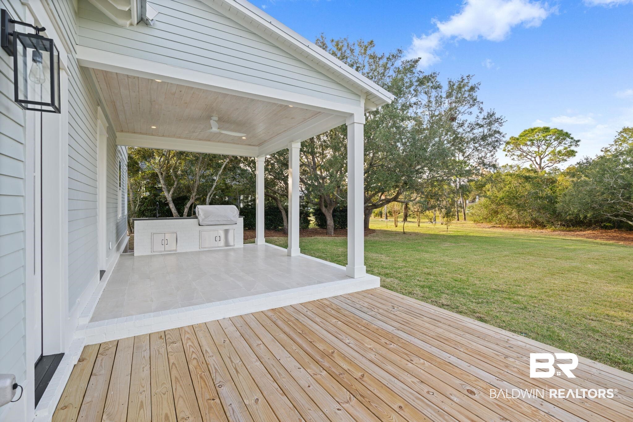 30313 River Road Orange Beach, AL 36561 - Photo 8 of 50 Wooden deck featuring ceiling fan, a yard, view of wooded area, and area for grilling