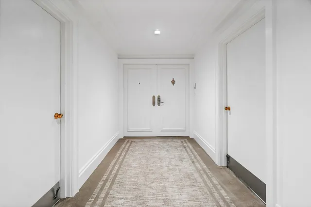 a view of a hallway with wooden floor and a window