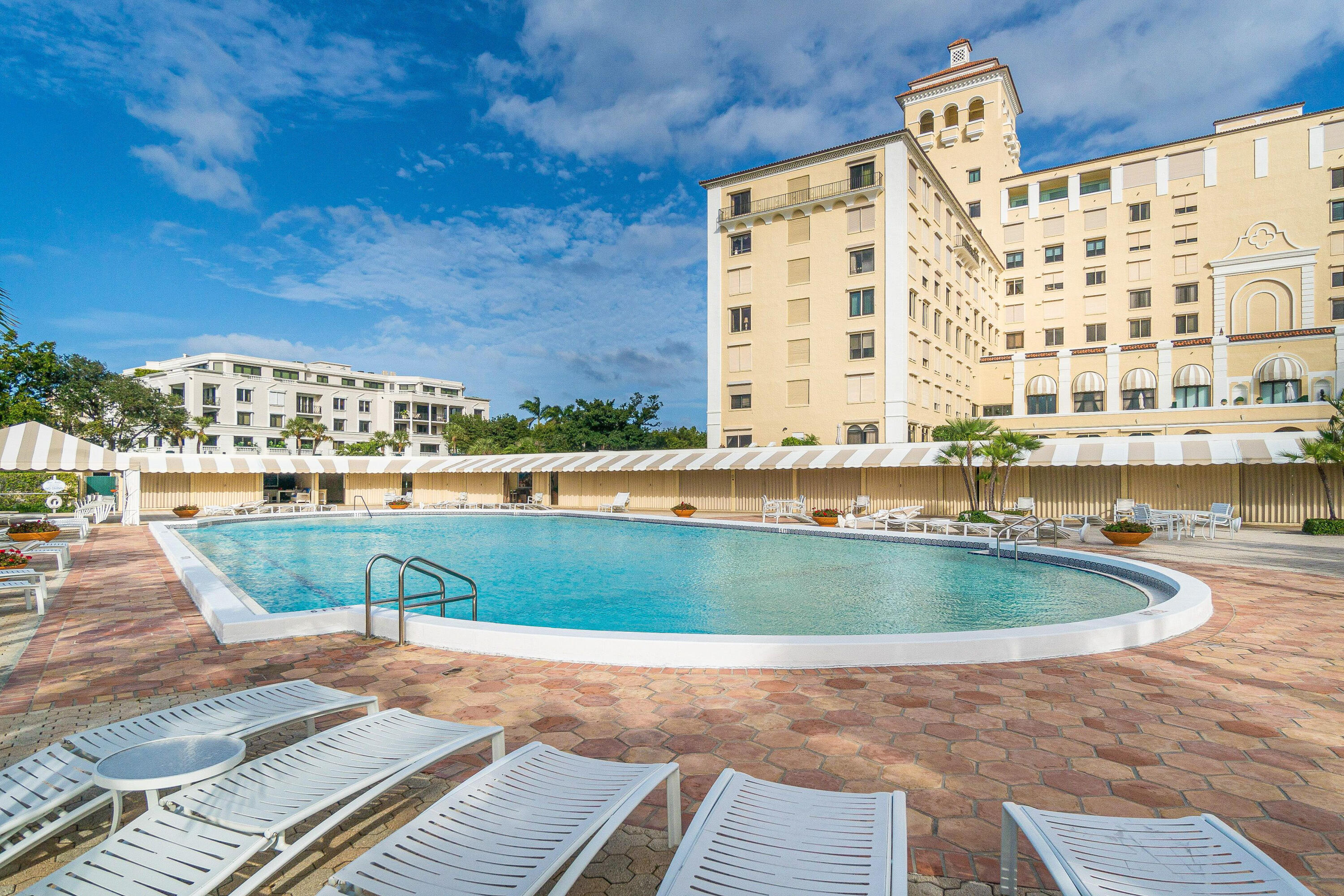 150 Bradley Place, Unit 101 Palm Beach, FL 33480 - Photo 34 of 38 a view of swimming pool with outdoor seating and buildings in the background
