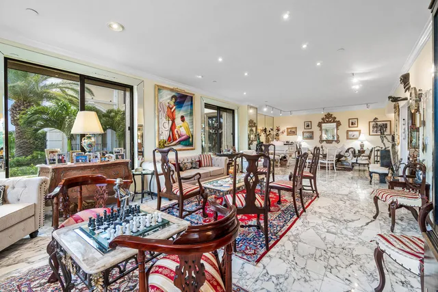 a living room with furniture kitchen view and a large window