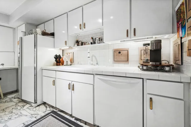 a kitchen with stainless steel appliances granite countertop a sink and a refrigerator