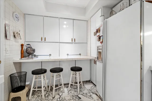 a kitchen with cabinets and chairs in it