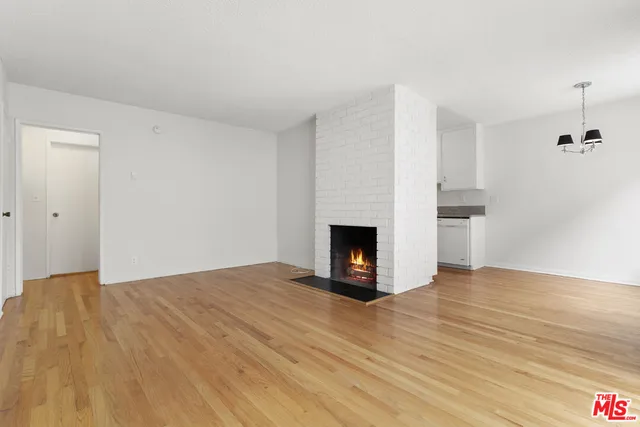 a view of empty room with wooden floor and fireplace
