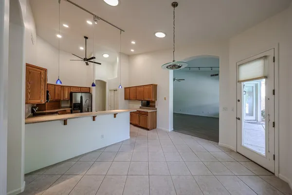 a kitchen with kitchen island granite countertop a sink and a refrigerator
