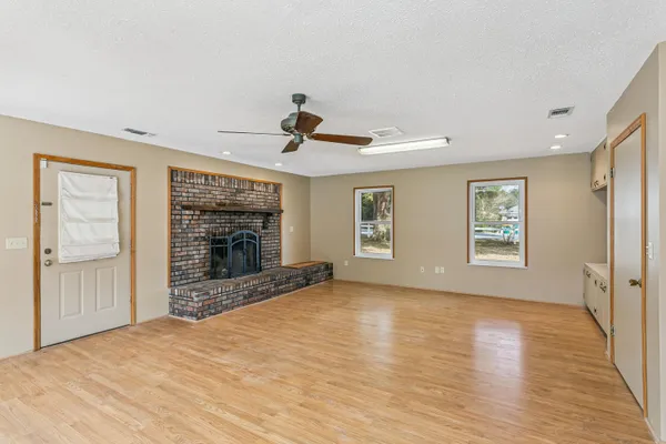 a view of an empty room with a window and fireplace