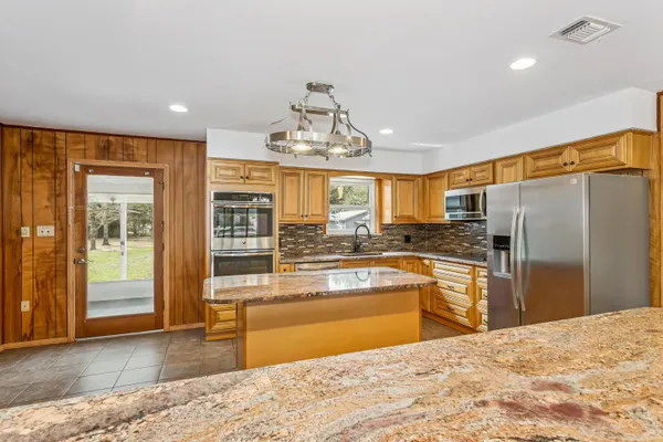 a kitchen with stainless steel appliances granite countertop a refrigerator and a sink