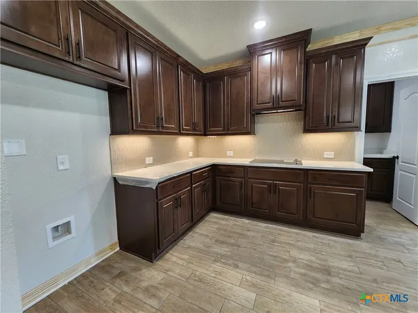 a large kitchen with stainless steel appliances a large counter top