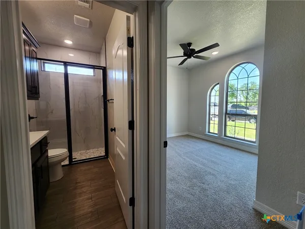 en empty room with windows and ceiling fan