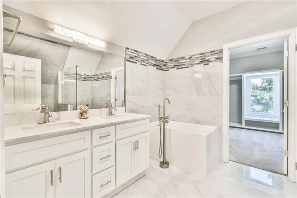 a spacious bathroom with a shower sink double vanity and a mirror