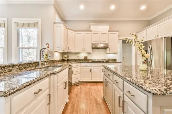 a kitchen with stainless steel appliances granite countertop a sink stove and refrigerator