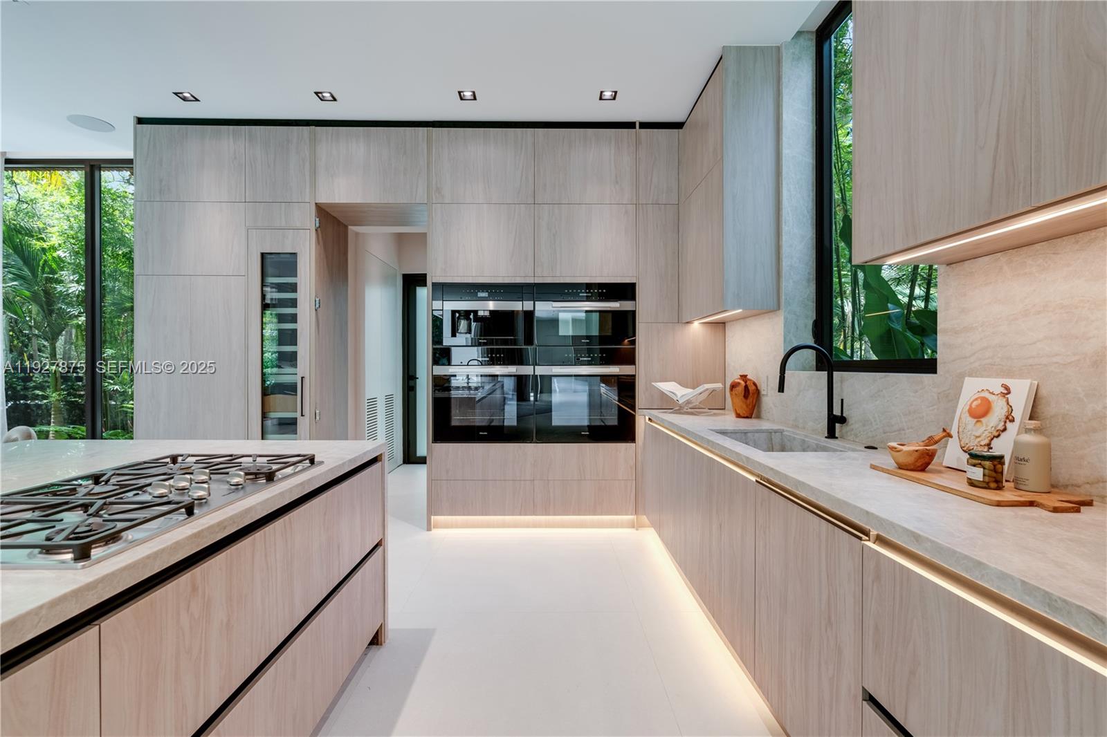 2800 Calusa Street Miami, FL 33133 - Photo 12 of 71 a kitchen with kitchen island granite countertop a sink stove and refrigerator