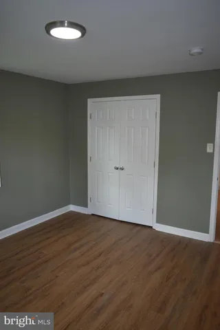 an empty room with wooden floor and closet