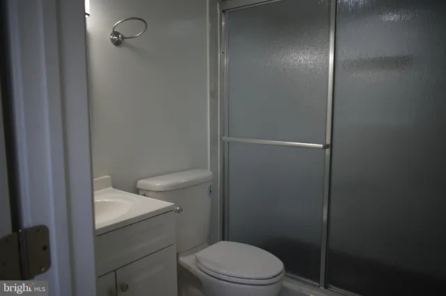 a bathroom with a granite countertop toilet a sink and shower