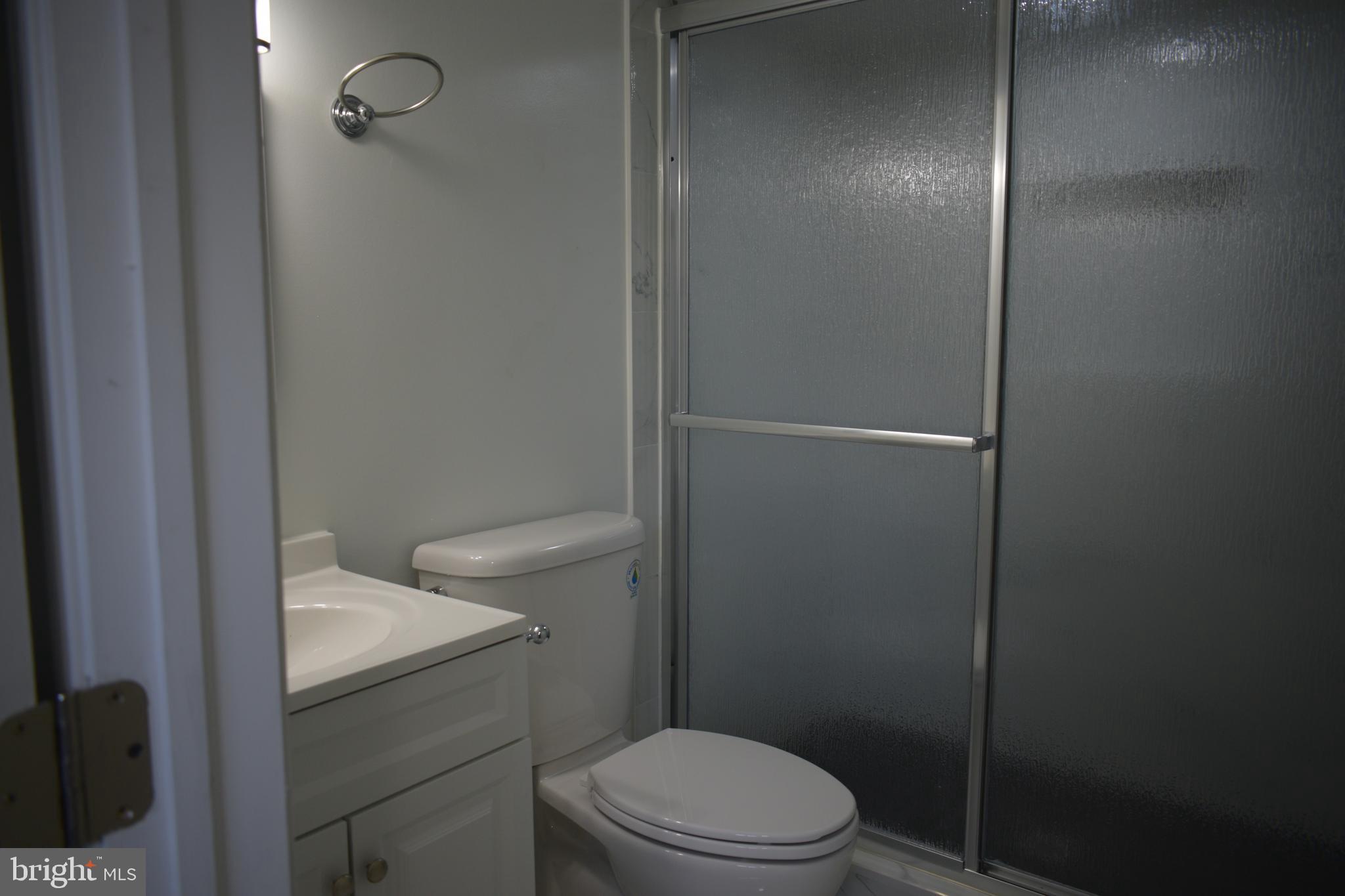 12323 Dewey Silver Spring Silver Spring, MD 20906 - Photo 27 of 37 a bathroom with a granite countertop toilet a sink and shower