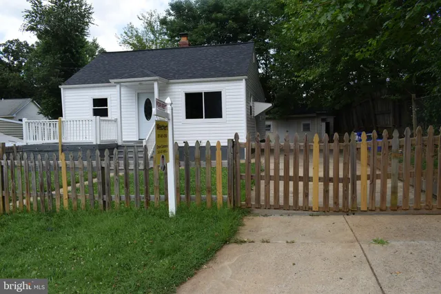 a white house that has tree in front of it