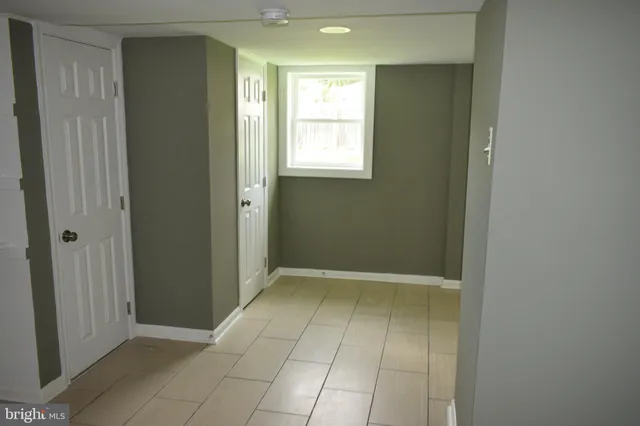a view of an empty room with window and bathroom