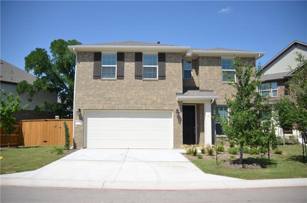 A classic brick facade with contrasting shutters and an attached garage offers inviting curb appeal.