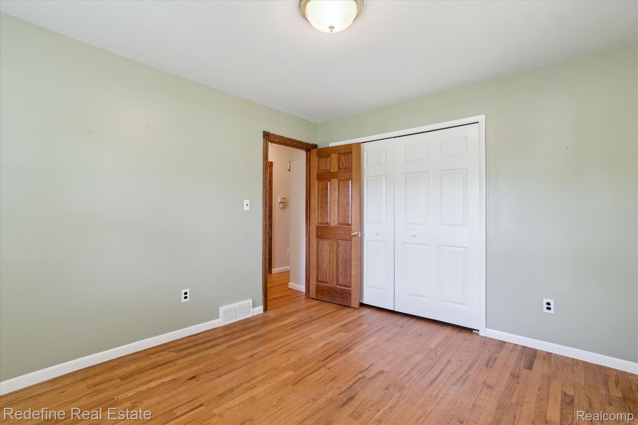 3777 Dorr Road Brighton, MI 48116 - Photo 33 of 77 Unfurnished bedroom with light wood-type flooring and a closet