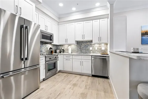a kitchen with stainless steel appliances a refrigerator sink and microwave