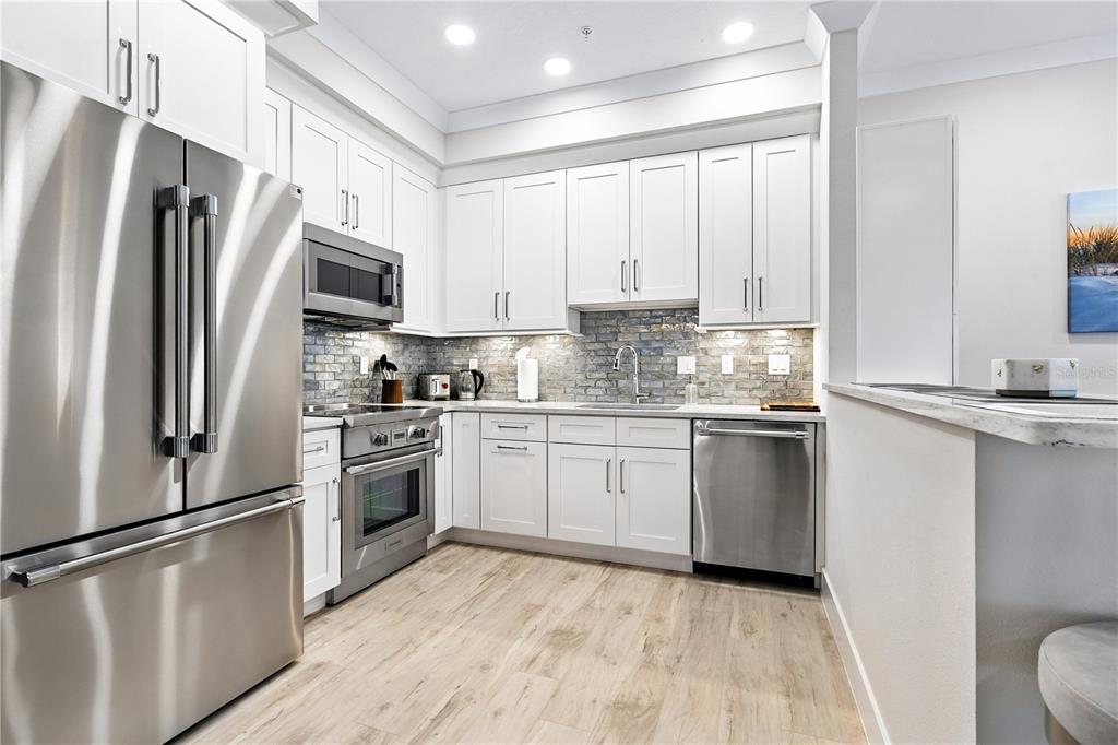 1234 15th Street, Unit 102 Sarasota, FL 34236 - Photo 11 of 30 a kitchen with stainless steel appliances a refrigerator sink and microwave
