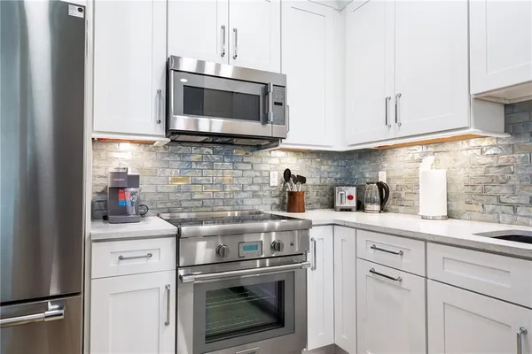 a kitchen with stainless steel appliances white cabinets and a sink