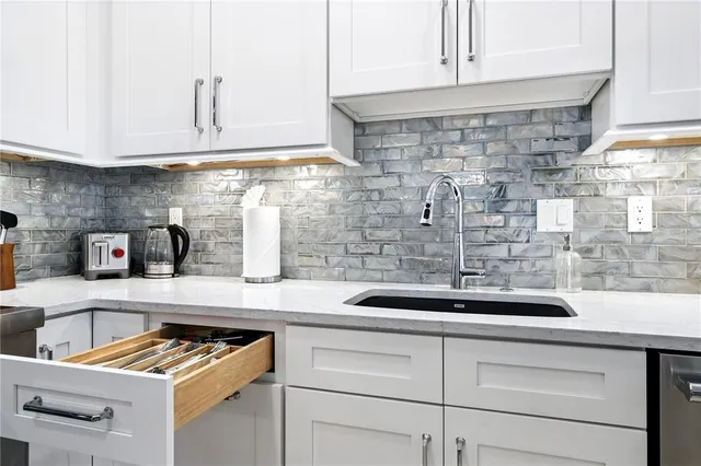 a kitchen with granite countertop a sink a stove and cabinets