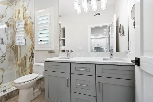 a bathroom with a double vanity sink mirror and toilet