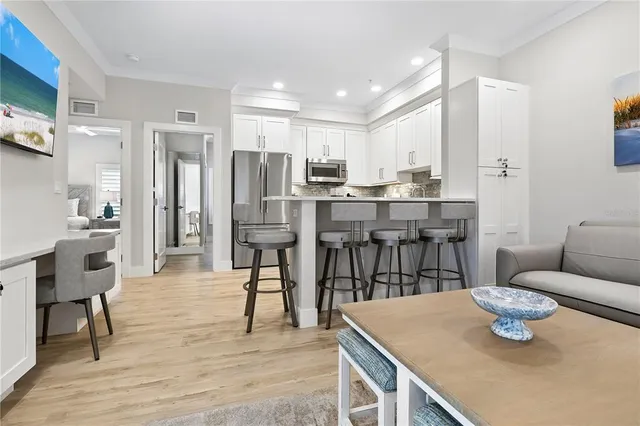 a living room with stainless steel appliances kitchen island granite countertop furniture and wooden floor