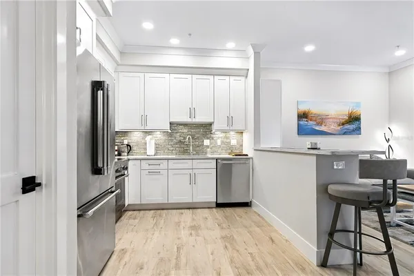 a kitchen with granite countertop a refrigerator stove top oven and sink