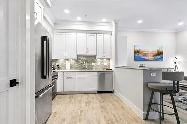 a kitchen with granite countertop a refrigerator stove top oven and sink