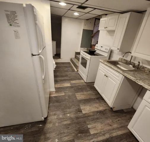 a kitchen with white cabinets and white appliances