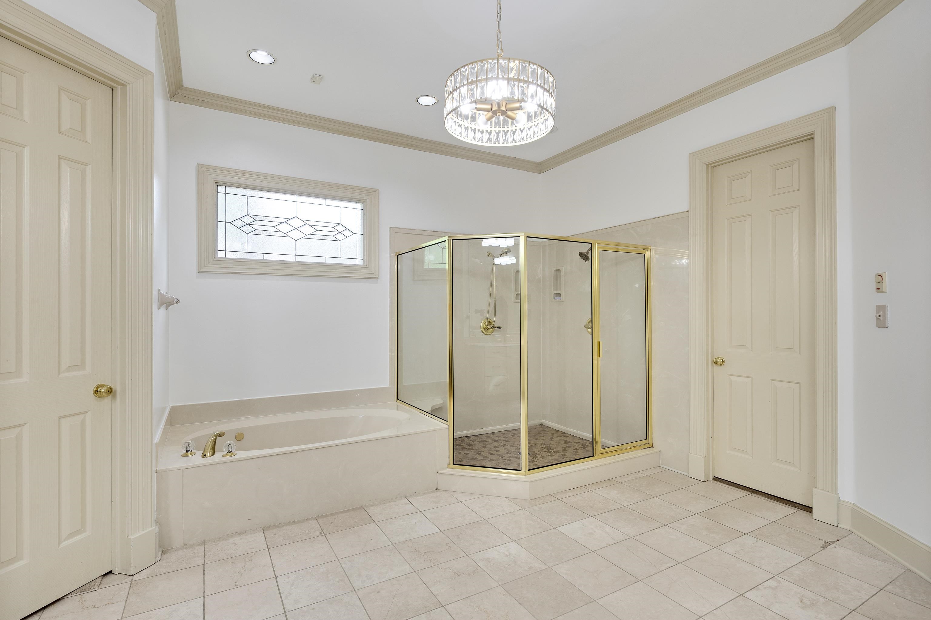 350 Bluff Ridge Cove Memphis, TN 38018 - Photo 27 of 37 Spacious bathroom featuring a built-in tub, separate glass-enclosed shower, tiled flooring, and a decorative frosted window