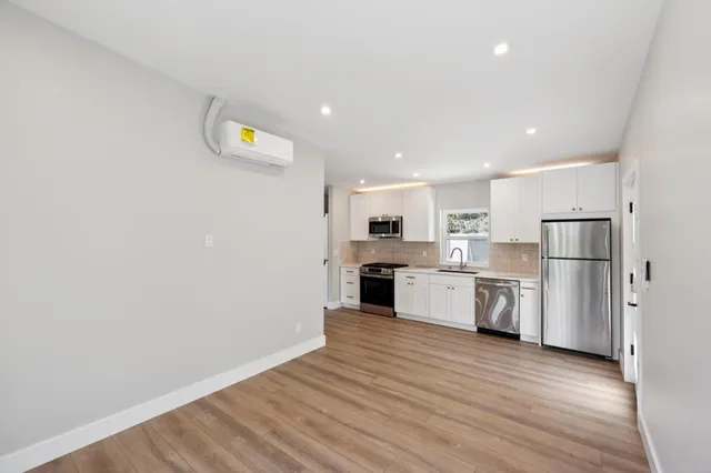 a kitchen with stainless steel appliances a stove microwave and sink