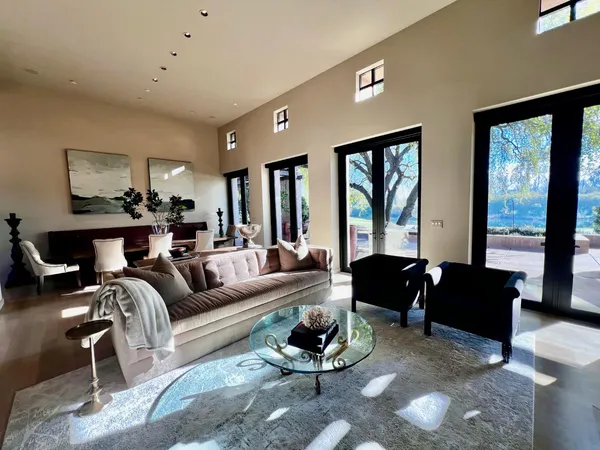 a living room with furniture fireplace and large windows