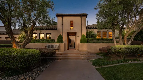 a front view of a house with a garden