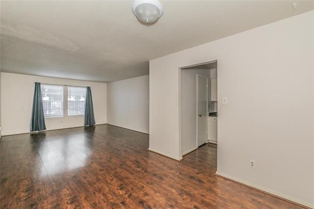 5111 Skillman Street, Unit 128 Dallas, TX 75206 - Photo 11 of 29 an empty room with wooden floor and windows