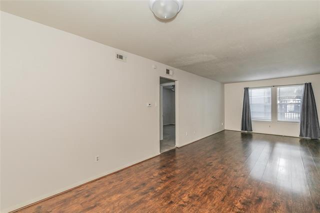 5111 Skillman Street, Unit 128 Dallas, TX 75206 - Photo 12 of 29 a view of an empty room with wooden floor and windows