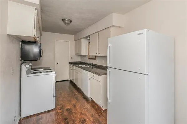 a kitchen with a refrigerator and a stove top oven