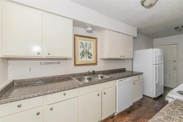 a kitchen with granite countertop cabinets stainless steel appliances a sink and a window