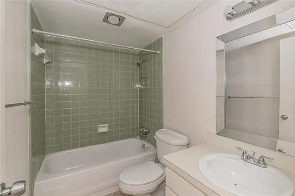 a bathroom with a bathtub shower sink mirror vanity and toilet