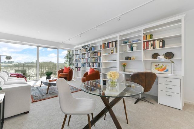 a living room with furniture and a floor to ceiling window